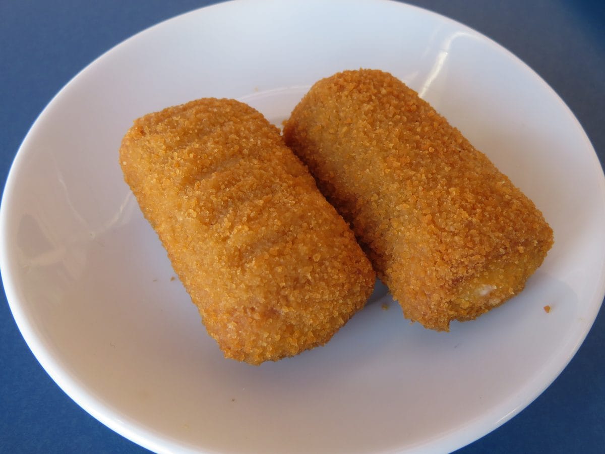 Two golden brown breaded croquettes on a white plate
