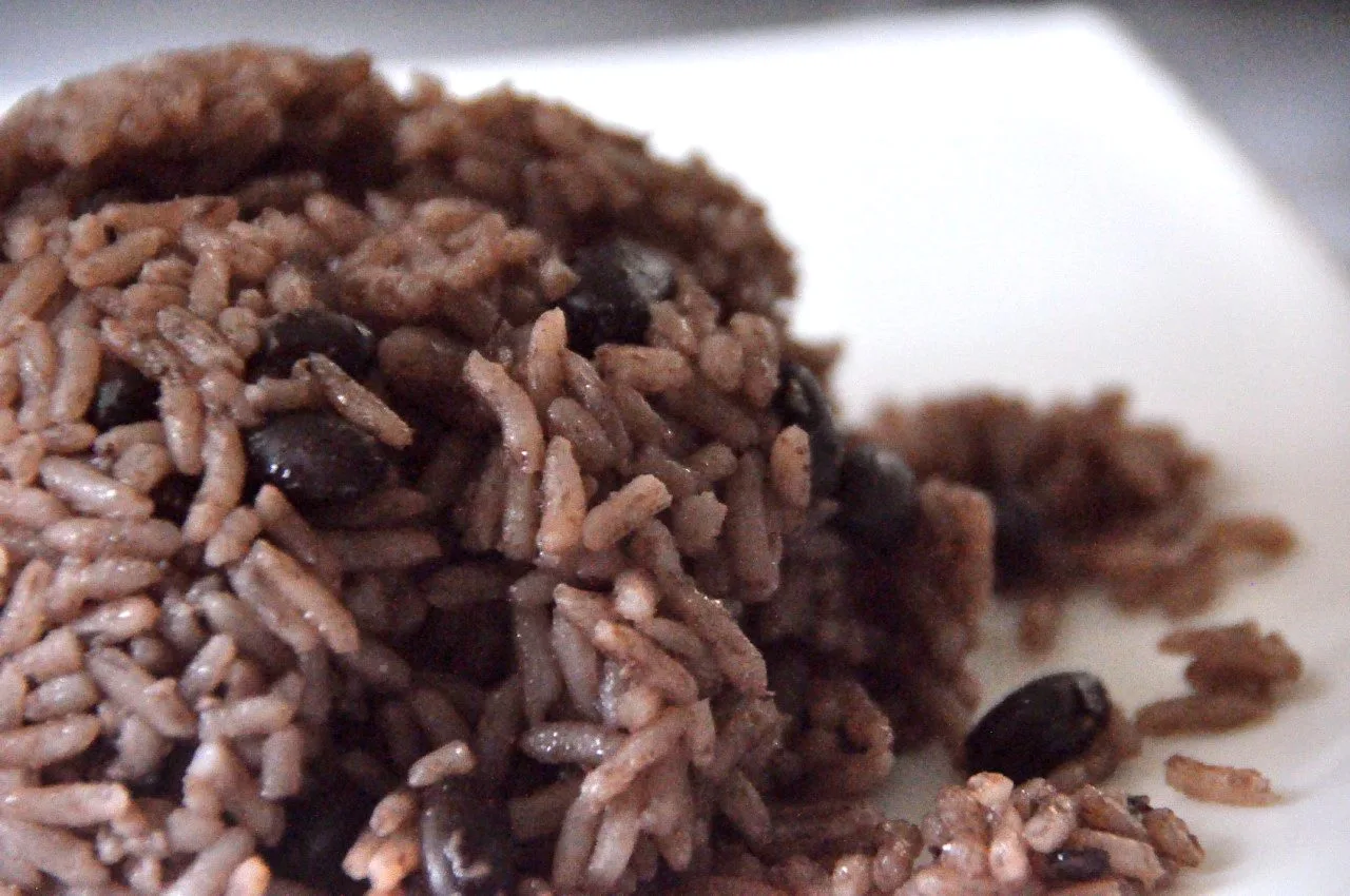 Close-up of moros y cristianos, black beans cooked together with white rice, served on a white plate