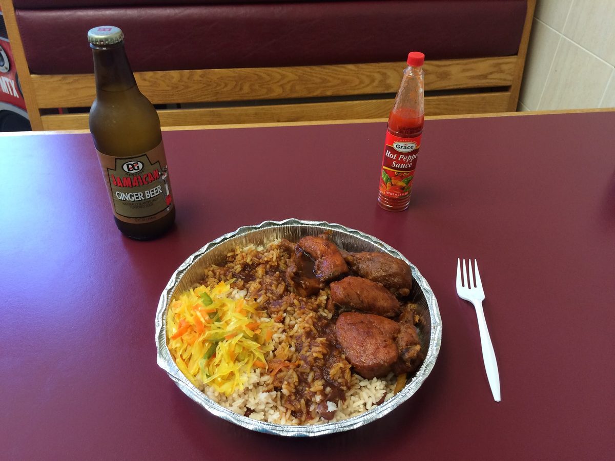 Jamaican brown stew chicken in gravy with rice and peas