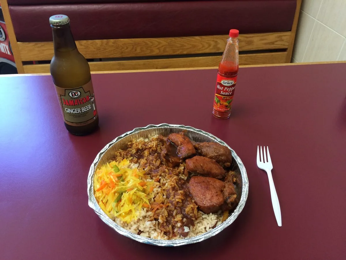 Jamaican brown stew chicken in gravy with rice and peas