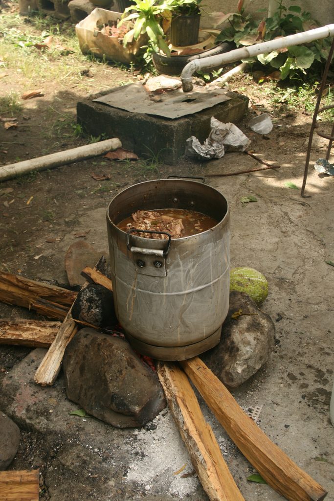 Mannish water, Jamaican goat soup, cooking outdoors over a wood fire