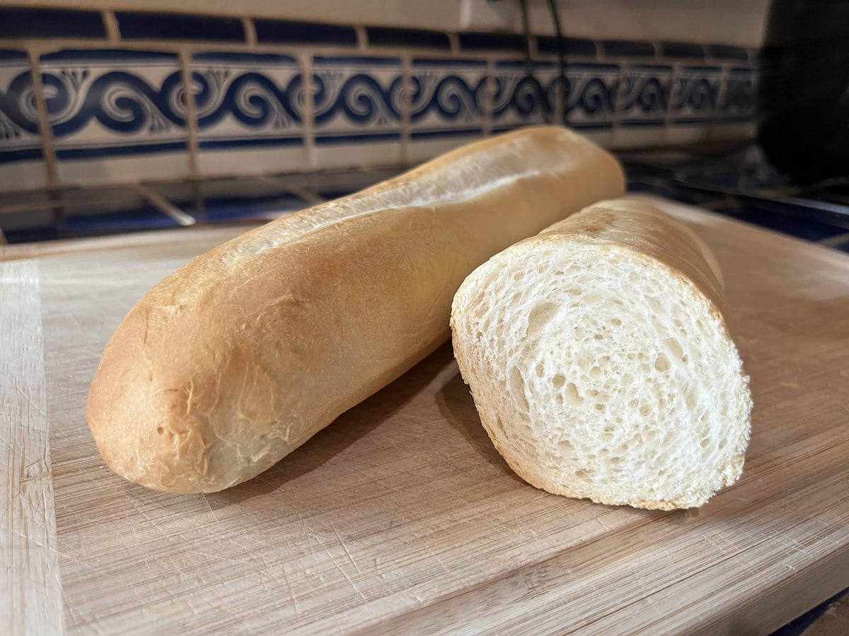 A long oval loaf of white bread with a seam running the length of the crust