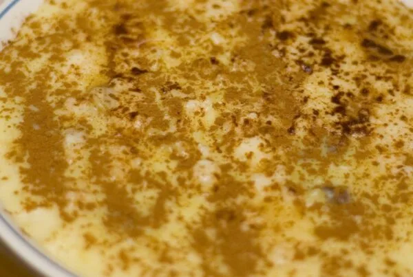 A bowl of rice pudding dusted heavily with ground cinnamon, the way arroz con dulce is finished