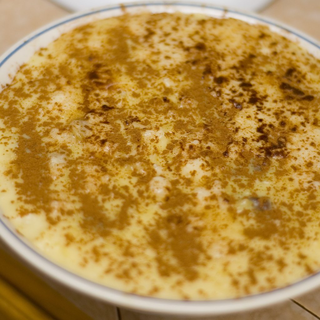 A bowl of rice pudding dusted heavily with ground cinnamon, the way arroz con dulce is finished
