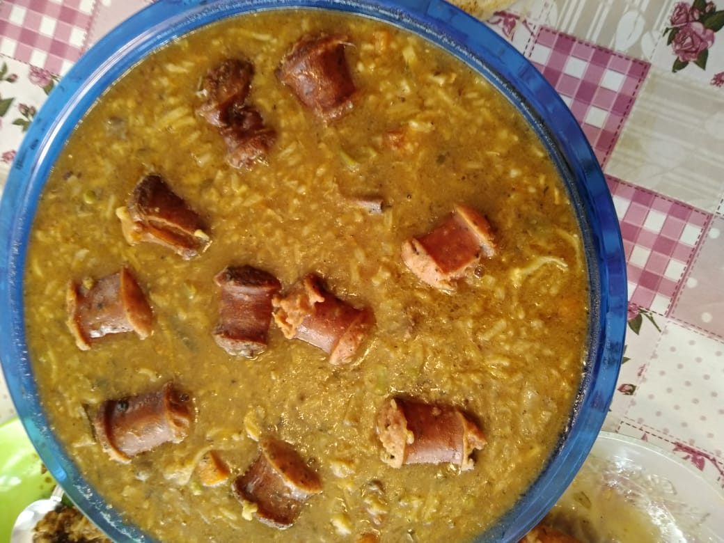 A bowl of Puerto Rican asopao, a thick rice stew, with rounds of sausage on top