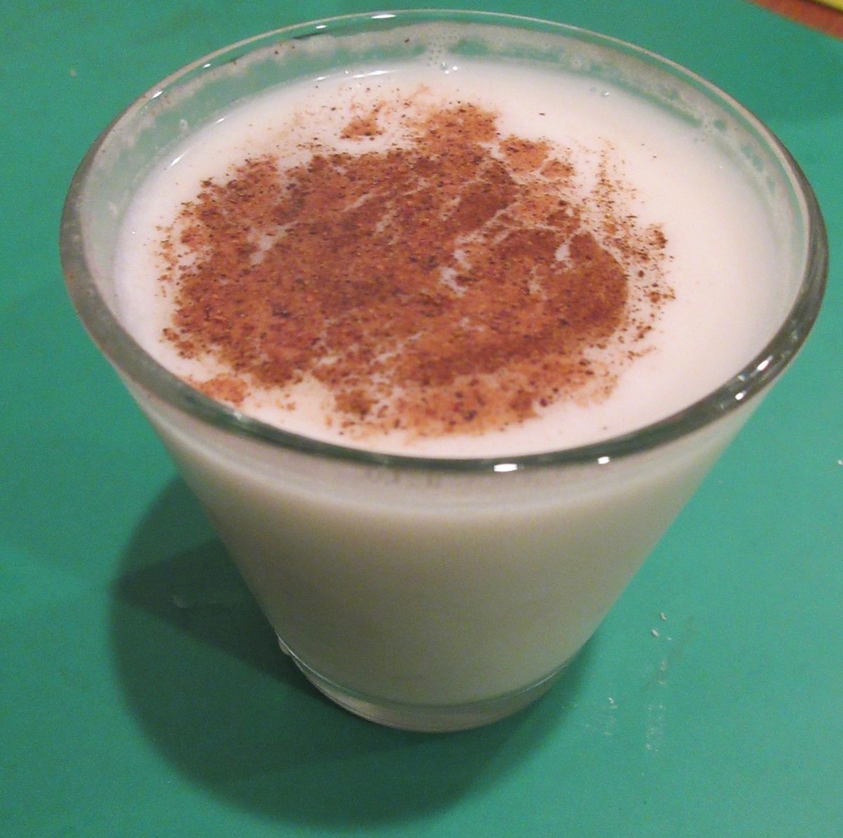 coquito served in a small glass with ground cinnamon and nutmeg dusted over the top