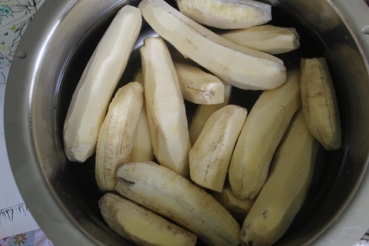Peeled green bananas soaking in a pot of water, the first step in making guineitos en escabeche