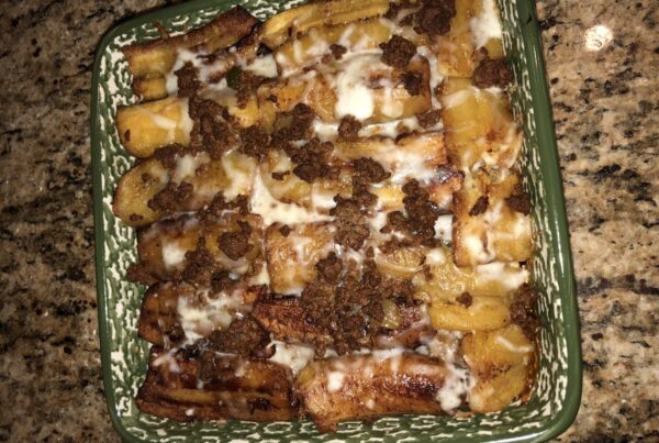 A baking dish of Puerto Rican pastelon: layers of fried ripe plantain with seasoned ground beef and melted cheese