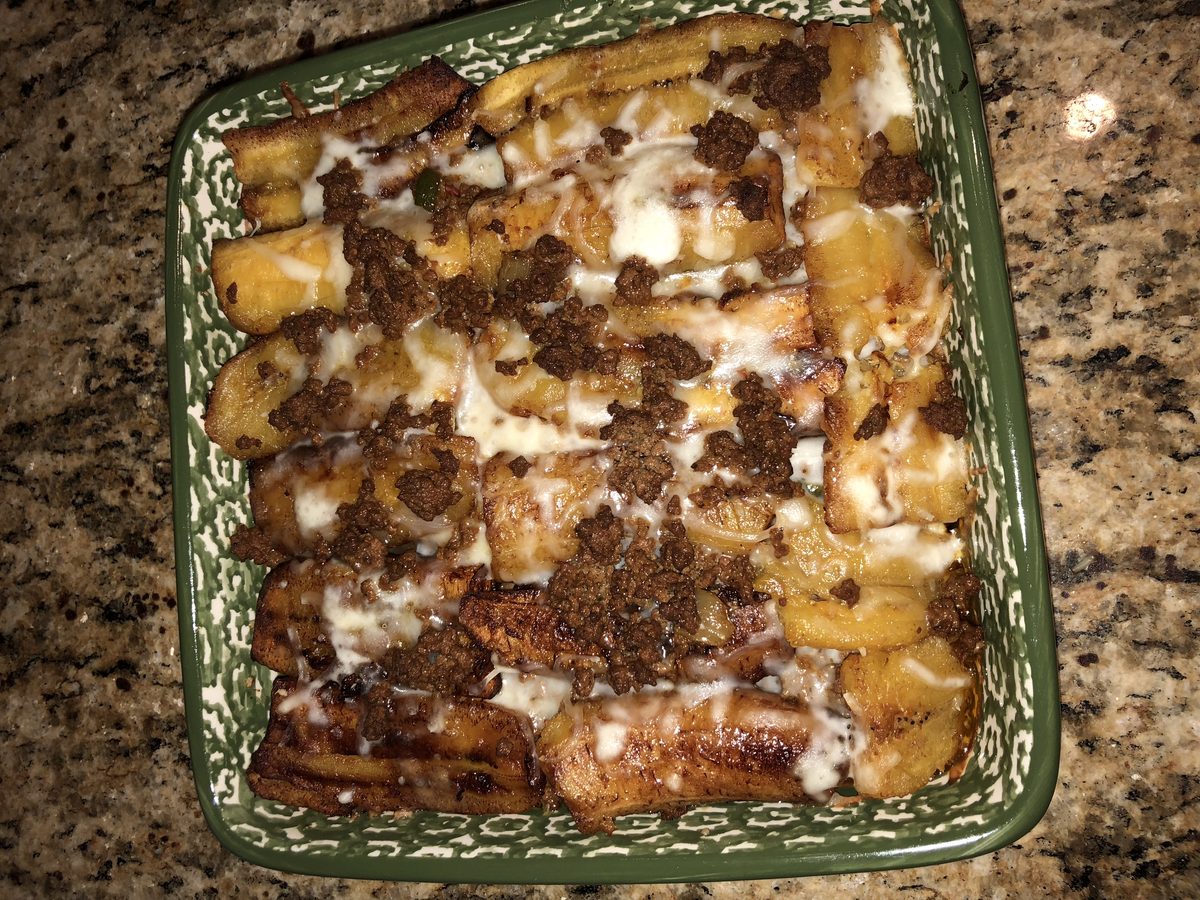 A baking dish of Puerto Rican pastelon: layers of fried ripe plantain with seasoned ground beef and melted cheese