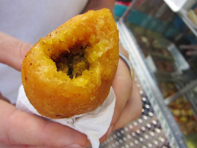 Puerto Rican relleno de papa broken open to show the picadillo filling