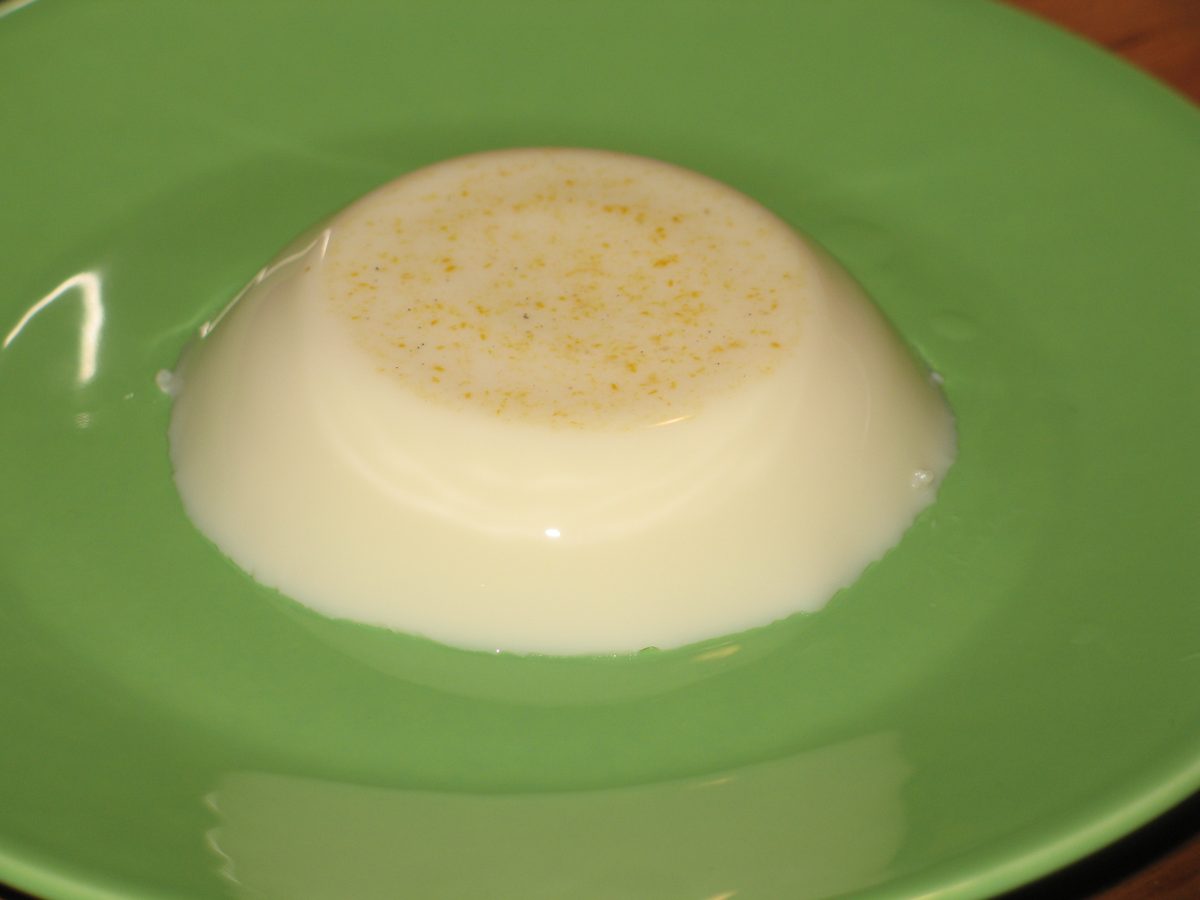 A white molded coconut pudding dusted with cinnamon, the shape tembleque takes when turned out of its mold