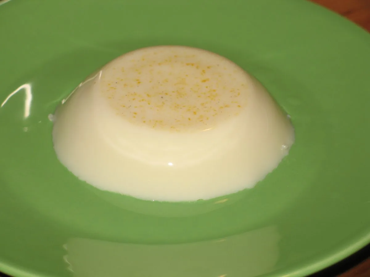 A white molded coconut pudding dusted with cinnamon, the shape tembleque takes when turned out of its mold