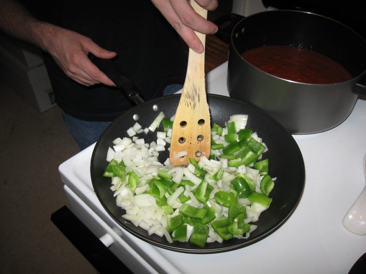 Chopped onion and green pepper frying in olive oil
