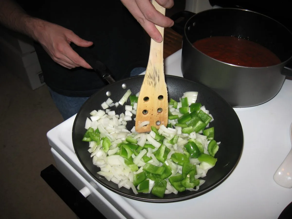 Chopped onion and green pepper frying in olive oil