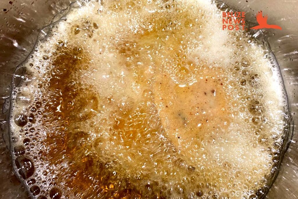 Deep frying Belizean fish panades.