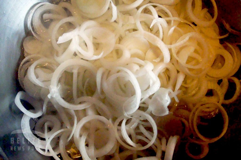 Freshly sliced white onions prepared for Belizean escabeche recipe.