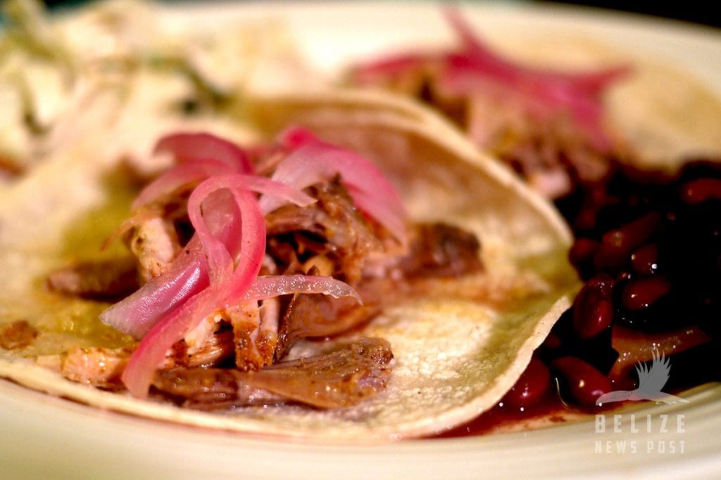 Cochinita Pibil recipe from Belize - Pork tacos with red pickled onions are ready to eat.