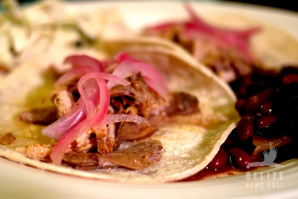 Cochinita Pibil recipe from Belize - Pork tacos with red pickled onions are ready to eat.