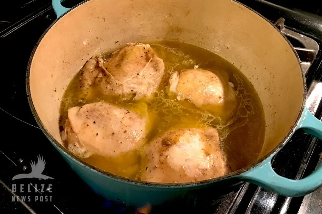 Belize stew chicken simmering in its gravy with potatoes
