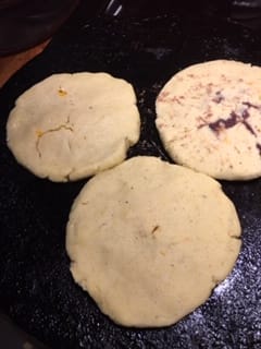 Papusas on the griddle cooking.