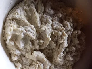 Recipe Step - Sifting bread flour into the dough mixture.