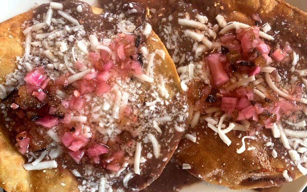 Fully assembled Belizean Garnaches with Black beans, Cortido (Red Onions pickled in white Vinegar) and Freshly Grated Cheese - Fully Recipe by Belize News Post 