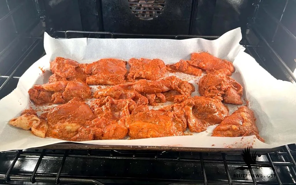 Recado Chicken Baked - Red Recado marinated chicken placed on a baking sheet.