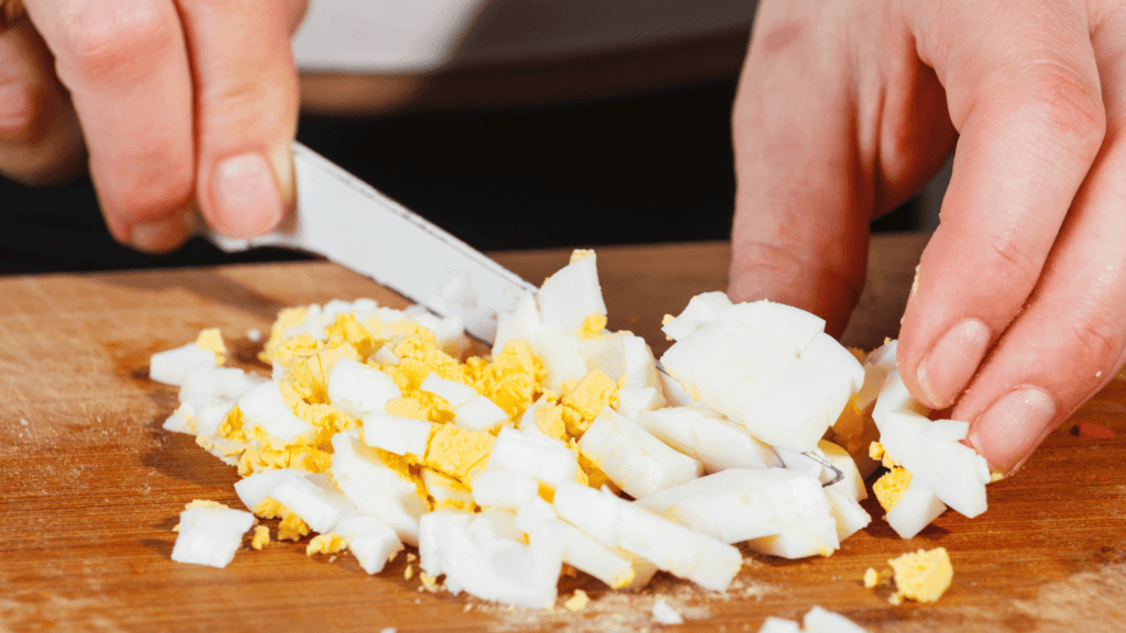 Chopping hard boiled eggs to add to browned ground pork then stuffed into chicken for Belizean Relleno. 